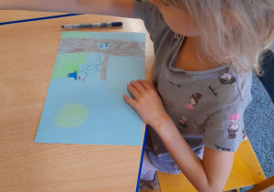 Dziewczynka rysuje wróbelka.